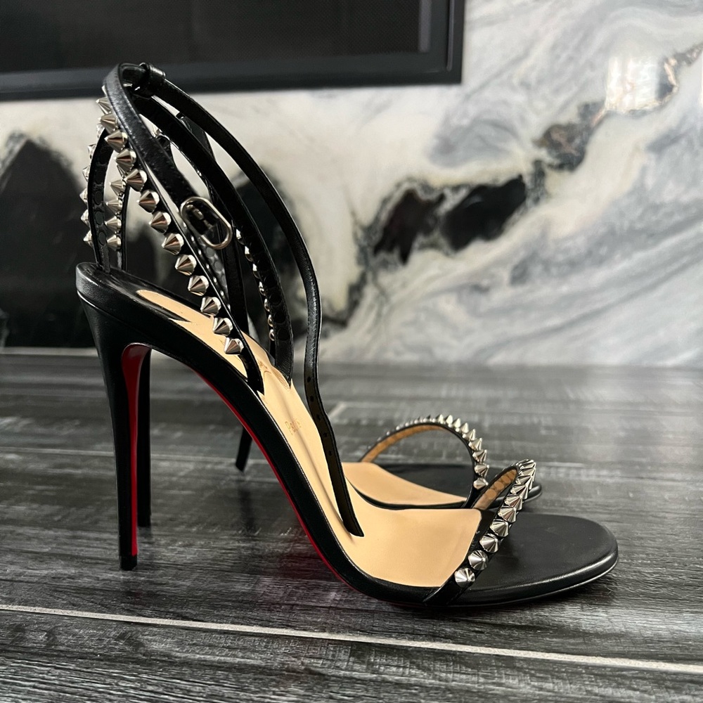 Christian Louboutin “So me”leather sandals with spike trim.